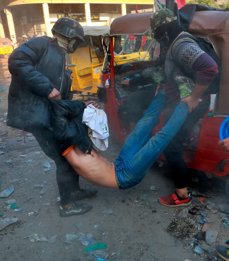 An injured protester is rushed to a hospital during clashes between security forces and anti-government protesters in Baghdad, Iraq, Sunday, Nov. 24, 2019. Hundreds of people have died since demonstrations began Oct. 1, when thousands of Iraqis, mostly youth, took to the streets to decry corruption and poor services. The leaderless uprising seeks to overthrow the political establishment. (AP Photo/Khalid Mohammed) An injured protester is rushed to a hospital during clashes between security forces and anti-government protesters in Baghdad, Iraq, Sunday, Nov. 24, 2019. Hundreds of people have died since demonstrations began Oct. 1, when thousands of Iraqis, mostly youth, took to the streets to decry corruption and poor services. The leaderless uprising seeks to overthrow the political establishment. (AP Photo/Khalid Mohammed)