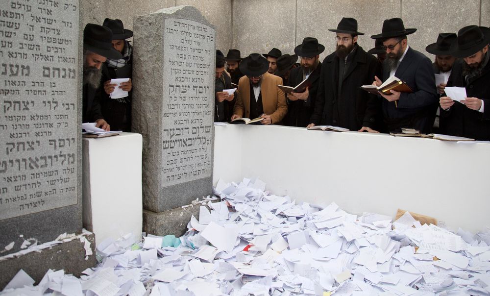 In this Nov. 22, 2019, photo, Hasidic leaders read personal notes and prayers at the resting place of the late Rabbi Menachem Mendel Schneerson, known as the Lubavitcher Rebbe, while attending the annual International Conference of Chabad-Lubavitch Emissaries at Montefiore Cemetery in New York. The annual conference included seminars, a class photo of about 5,800 rabbis in attendance and an evening dinner. (AP Photo/Jessie Wardarski) In this Nov. 22, 2019, photo, Hasidic leaders read personal notes and prayers at the resting place of the late Rabbi Menachem Mendel Schneerson, known as the Lubavitcher Rebbe, while attending the annual International Conference of Chabad-Lubavitch Emissaries at Montefiore Cemetery in New York. The annual conference included seminars, a class photo of about 5,800 rabbis in attendance and an evening dinner. (AP Photo/Jessie Wardarski)