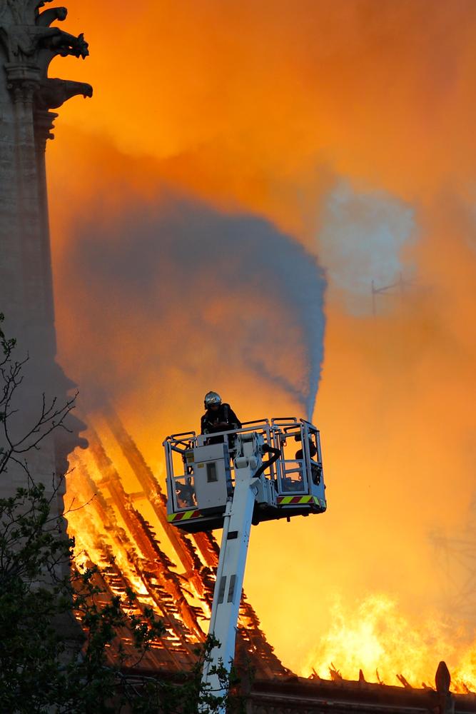 A fire fighter uses a hose as Notre Dame cathedral is burning in Paris, Monday, April 15, 2019. A catastrophic fire engulfed the upper reaches of Paris' soaring Notre Dame Cathedral as it was undergoing renovations Monday, threatening one of the greatest architectural treasures of the Western world as tourists and Parisians looked on aghast from the streets below. (AP Photo/Francois Mori) A fire fighter uses a hose as Notre Dame cathedral is burning in Paris, Monday, April 15, 2019. A catastrophic fire engulfed the upper reaches of Paris' soaring Notre Dame Cathedral as it was undergoing renovations Monday, threatening one of the greatest architectural treasures of the Western world as tourists and Parisians looked on aghast from the streets below. (AP Photo/Francois Mori)