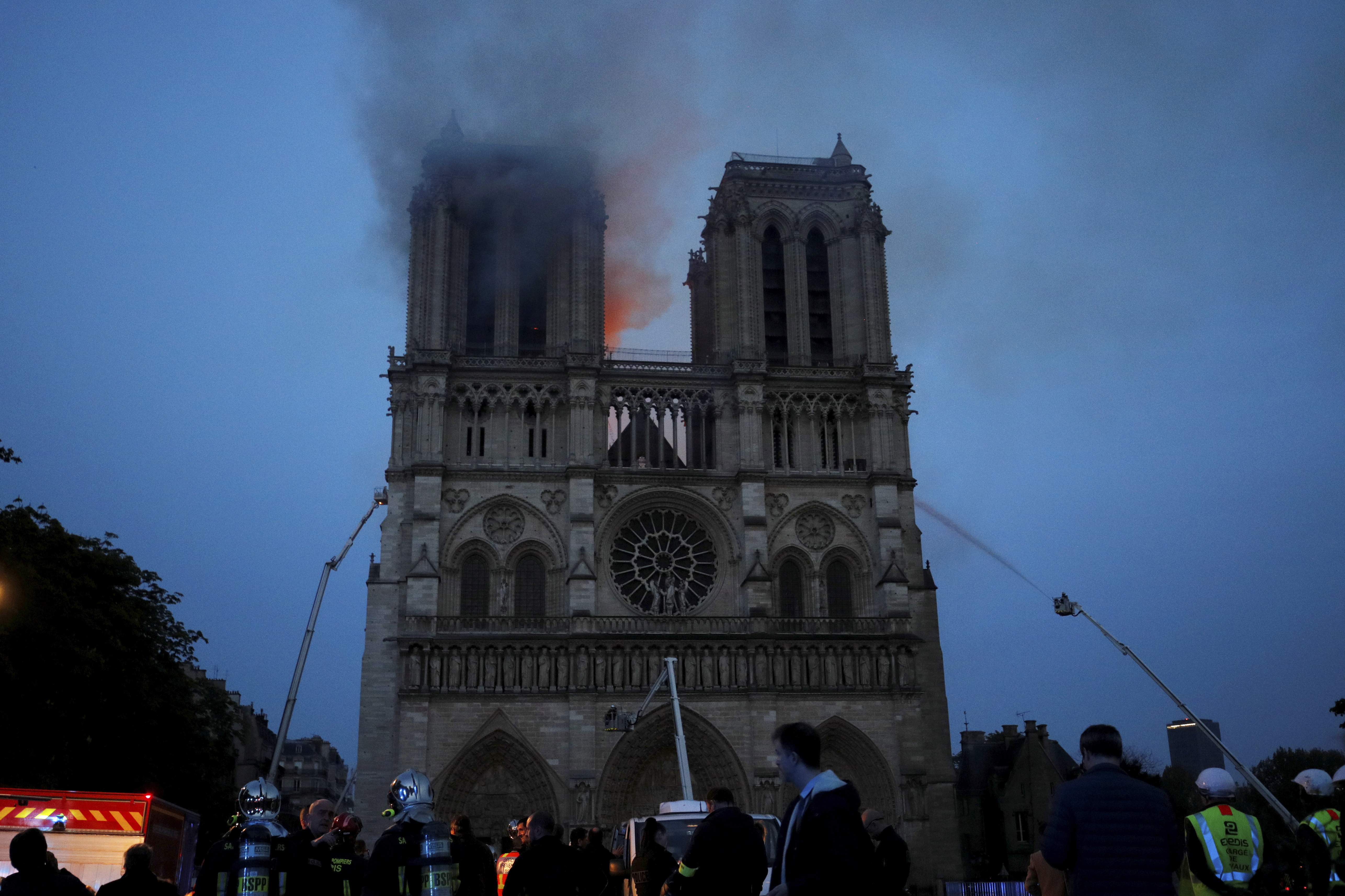 Smoke and flames fill the sky as a fire burns at the Notre Dame Cathedral during the visit by French President Emmanuel Macron in Paris, Monday, April 15, 2019. A catastrophic fire engulfed the upper reaches of Paris' soaring Notre Dame Cathedral as it was undergoing renovations Monday, threatening one of the greatest architectural treasures of the Western world as tourists and Parisians looked on aghast from the streets below.(Philippe Wojazer/Pool via AP) Smoke and flames fill the sky as a fire burns at the Notre Dame Cathedral during the visit by French President Emmanuel Macron in Paris, Monday, April 15, 2019. A catastrophic fire engulfed the upper reaches of Paris' soaring Notre Dame Cathedral as it was undergoing renovations Monday, threatening one of the greatest architectural treasures of the Western world as tourists and Parisians looked on aghast from the streets below.(Philippe Wojazer/Pool via AP)