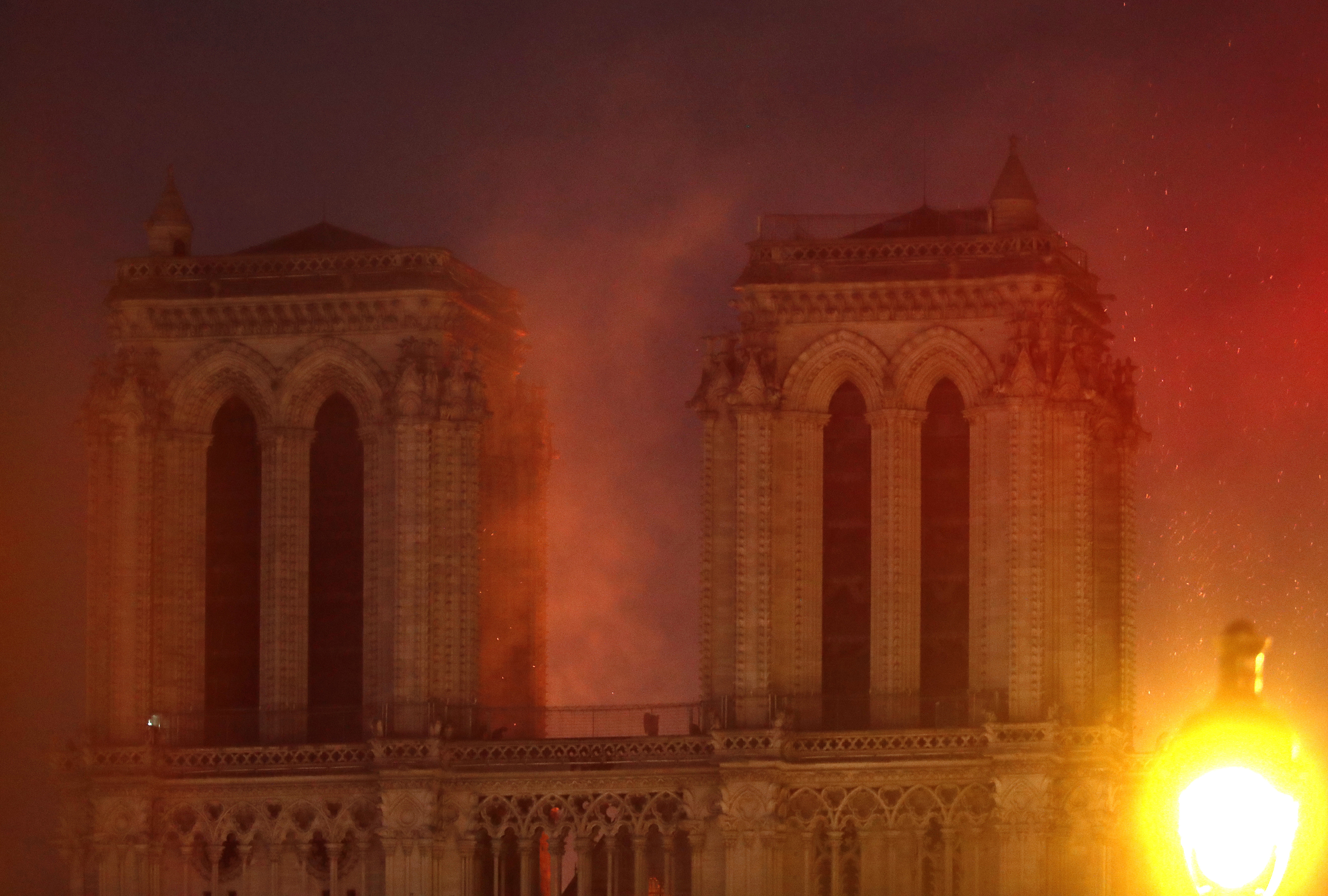 Flames illuminate the night sky as Notre Dame cathedral burns in Paris, Monday, April 15, 2019. Massive plumes of yellow brown smoke is filling the air above Notre Dame Cathedral and ash is falling on tourists and others around the island that marks the center of Paris. (AP Photo/Thibault Camus) Flames illuminate the night sky as Notre Dame cathedral burns in Paris, Monday, April 15, 2019. Massive plumes of yellow brown smoke is filling the air above Notre Dame Cathedral and ash is falling on tourists and others around the island that marks the center of Paris. (AP Photo/Thibault Camus)