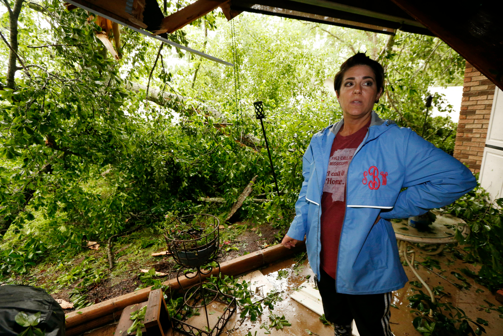 Sonya Banes reacts to a large oak tree that crashed through the patio of her mother's house in Learned, Miss., Thursday, April 18, 2019. Several homes were damaged by fallen trees in the community. Strong storms again roared across the South on Thursday, topping trees and leaving more than 100,000 people without power across Mississippi, Louisiana and Texas. (AP Photo/Rogelio V. Solis) Sonya Banes reacts to a large oak tree that crashed through the patio of her mother's house in Learned, Miss., Thursday, April 18, 2019. Several homes were damaged by fallen trees in the community. Strong storms again roared across the South on Thursday, topping trees and leaving more than 100,000 people without power across Mississippi, Louisiana and Texas. (AP Photo/Rogelio V. Solis)
